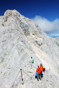 Low angle view of people on mountain against sky