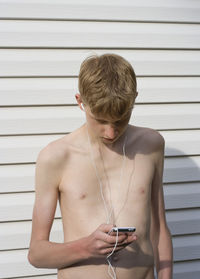 Midsection of shirtless man using mobile phone