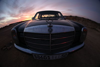 Close-up of vintage car on road against sky