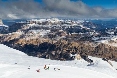 People on snowcapped mountain against sky