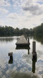 Wooden structure in lake against sky