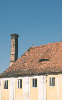 Low angle view of old building against clear blue sky