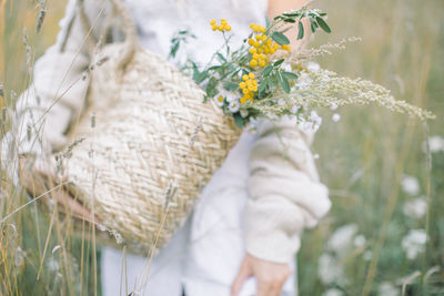 Woman standing by white flowering plants