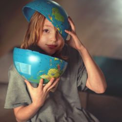 Portrait of happy girl holding globe