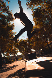 Low angle view of man jumping on tree