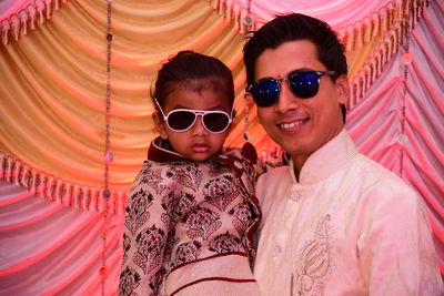 Portrait of father and son wearing sunglasses during celebration