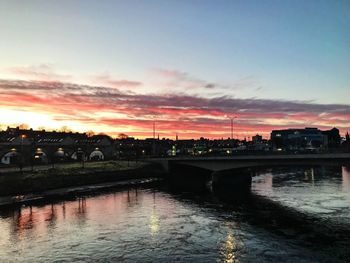 Bridge over river against sky during sunset