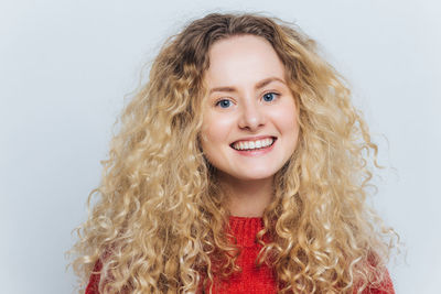 Portrait of young woman against blue background