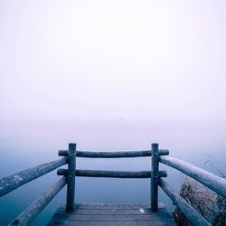 Suspension bridge over sea against clear sky