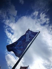 Low angle view of flag against blue sky