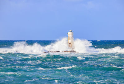 The lighthouse of the mangiabarche shrouded by the waves of a mistral wind storm

