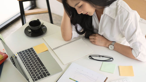 High angle view of woman using laptop on table