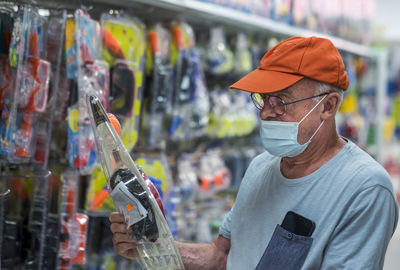 Man looking at toy hanging in shop