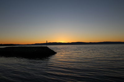 Scenic view of sea against clear sky during sunset