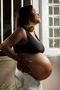 Side view of pregnant woman standing outdoors