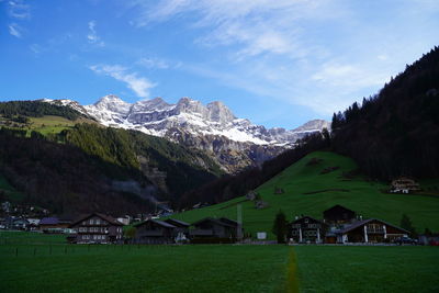 Scenic view of houses and mountains against sky