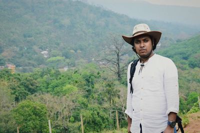 Man standing by trees against mountains