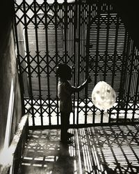 Rear view of woman standing on tiled floor