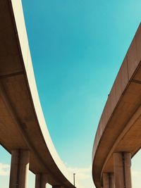 Low angle view of elevated road against clear blue sky