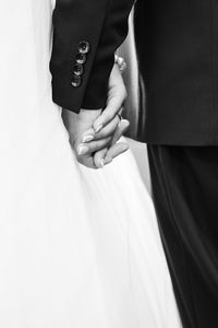 Close-up of bride and groom holding hands