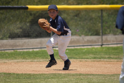Little league baseball infielder fielding a ground ball