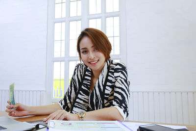 Portrait of young woman sitting on table