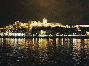 Illuminated buildings with waterfront at night