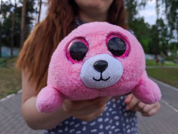 Close-up portrait of girl with pink toy