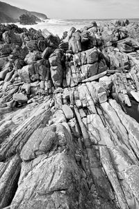 Rock formation on beach against sky