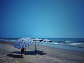 Rear view of person on beach against clear sky