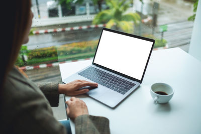 Midsection of woman using laptop