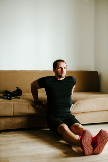 Portrait of man sitting on floor at home