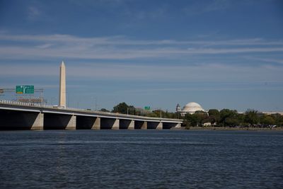 Bridge over sea against sky in city