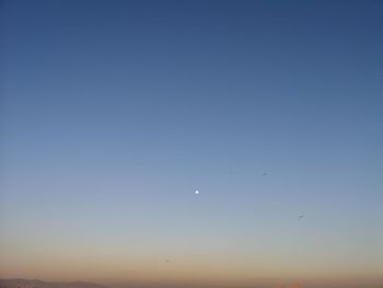 Low angle view of moon in sky at dusk