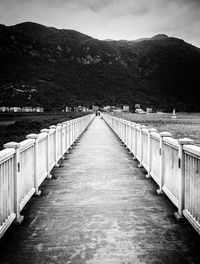 View of footpath leading towards mountain against sky