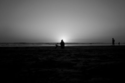 Silhouette man on beach against sky