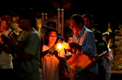 People sitting by fire at night