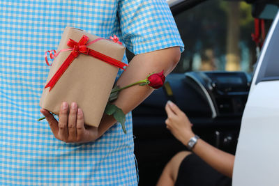 Midsection of couple holding hands in car