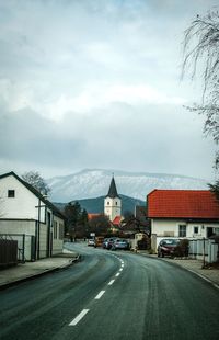 Road by building against sky