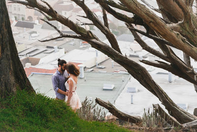 Couple romancing by tree in city