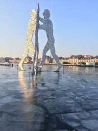 Sculpture in city against clear sky