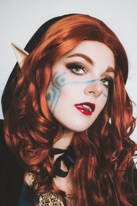 Close-up portrait of young woman against black background