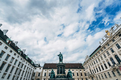 Low angle view of hofburg complex against cloudy sky