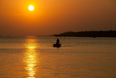 Silhouette of boat in sea at sunset