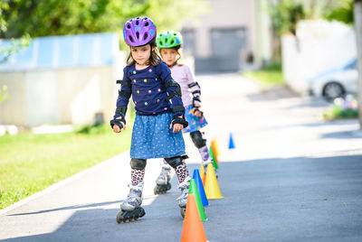 Girls roller skating through cones on road