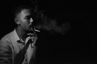 Portrait of young man smoking cigarette