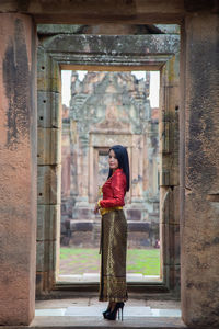 Portrait asian woman in thai tradition clothing posting in front of the gate of prasat muang tam,