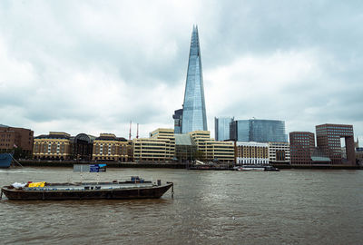 Boats in sea against cloudy sky