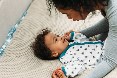 High angle view of baby lying on bed