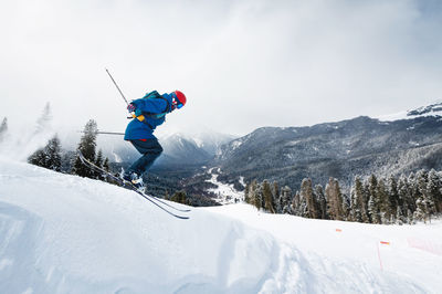 Good skiing in snowy mountains. a nice winter day, an incredible ski jump from which a skier jumps